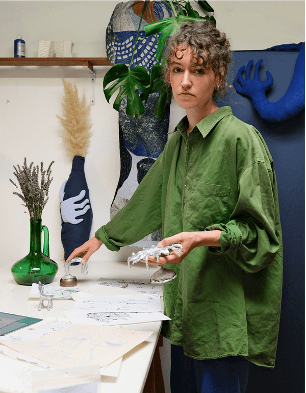 portrait of olga in her atelier holding sculptures